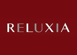 赤い背景に「RELUXIA」という文字が白とグレーで配置されたロゴデザインです。シンプルで洗練された印象を与えます。