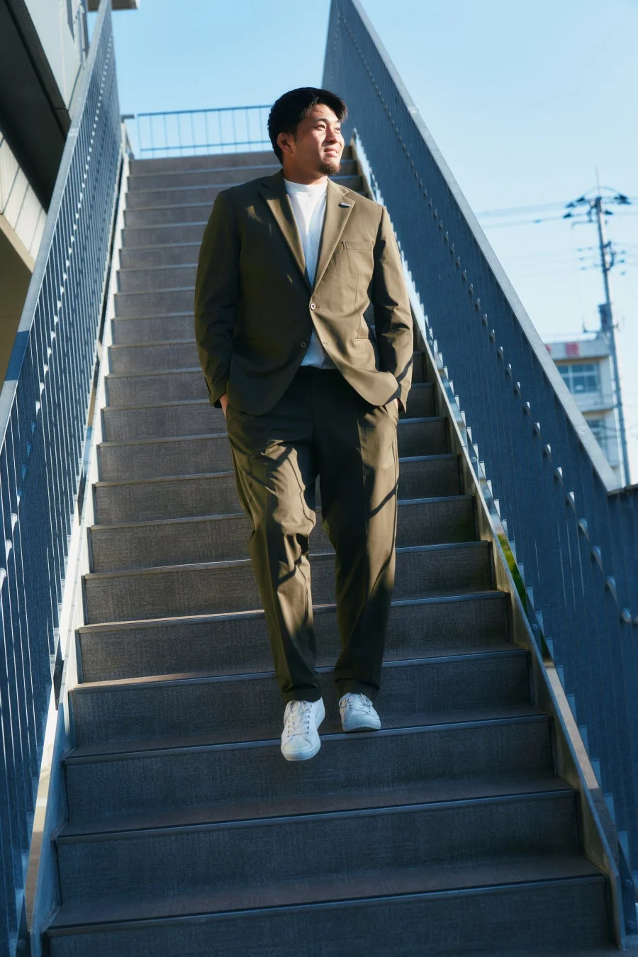 カジュアルなスーツを着て階段を降りる男性