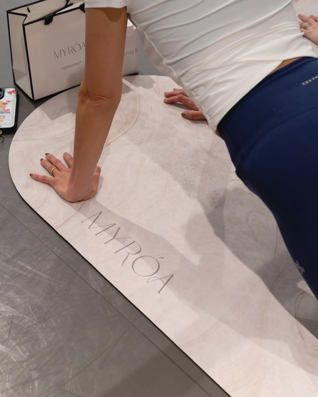 MYRÓAのロゴが入ったヨガマットの上でエクササイズをする女性