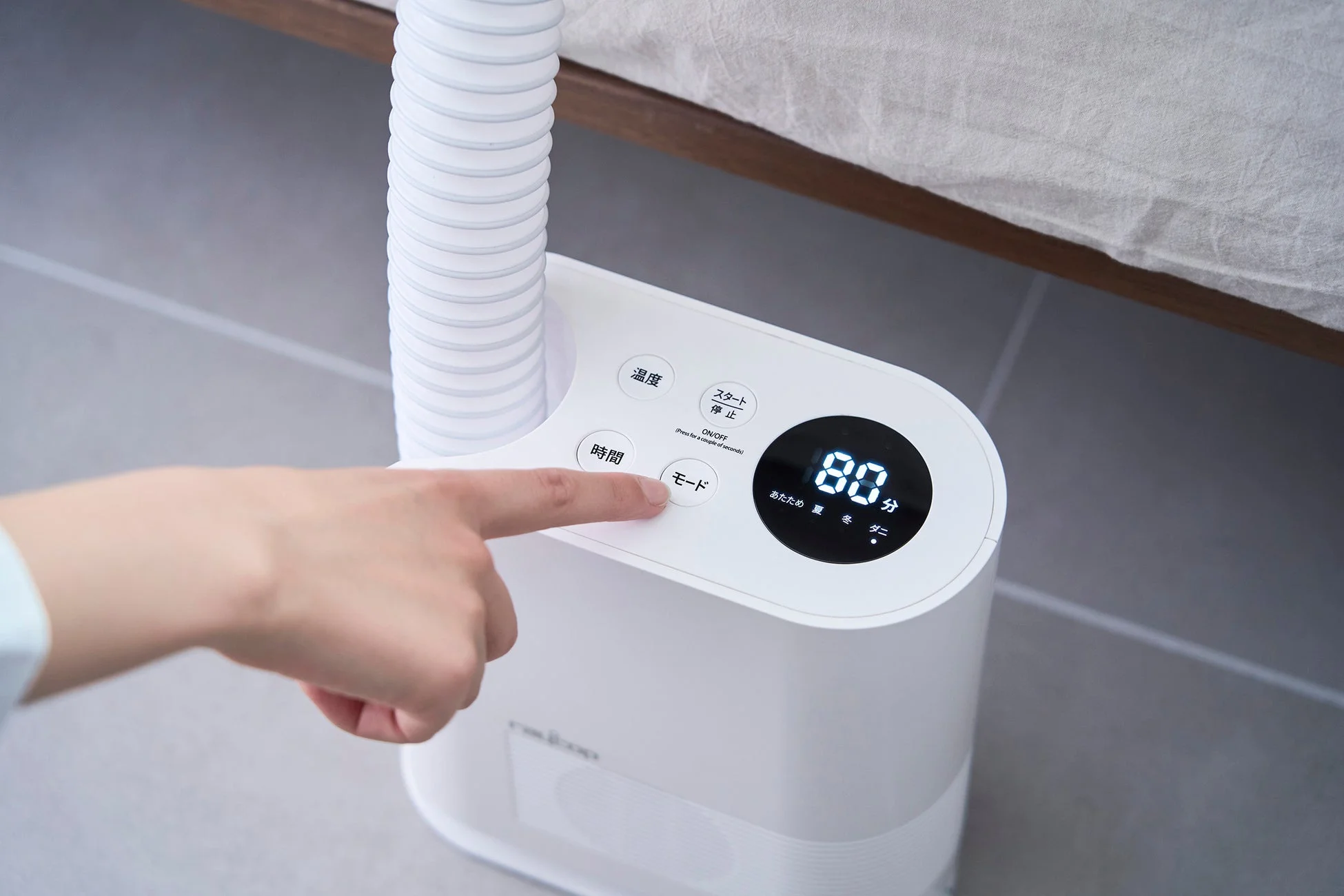 布団乾燥機を操作する様子