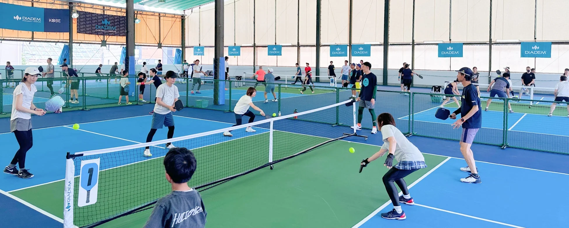 屋内ピクルボールコートでプレイする人々