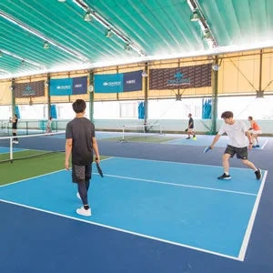 屋内コートでピクルボールを楽しむ人々
