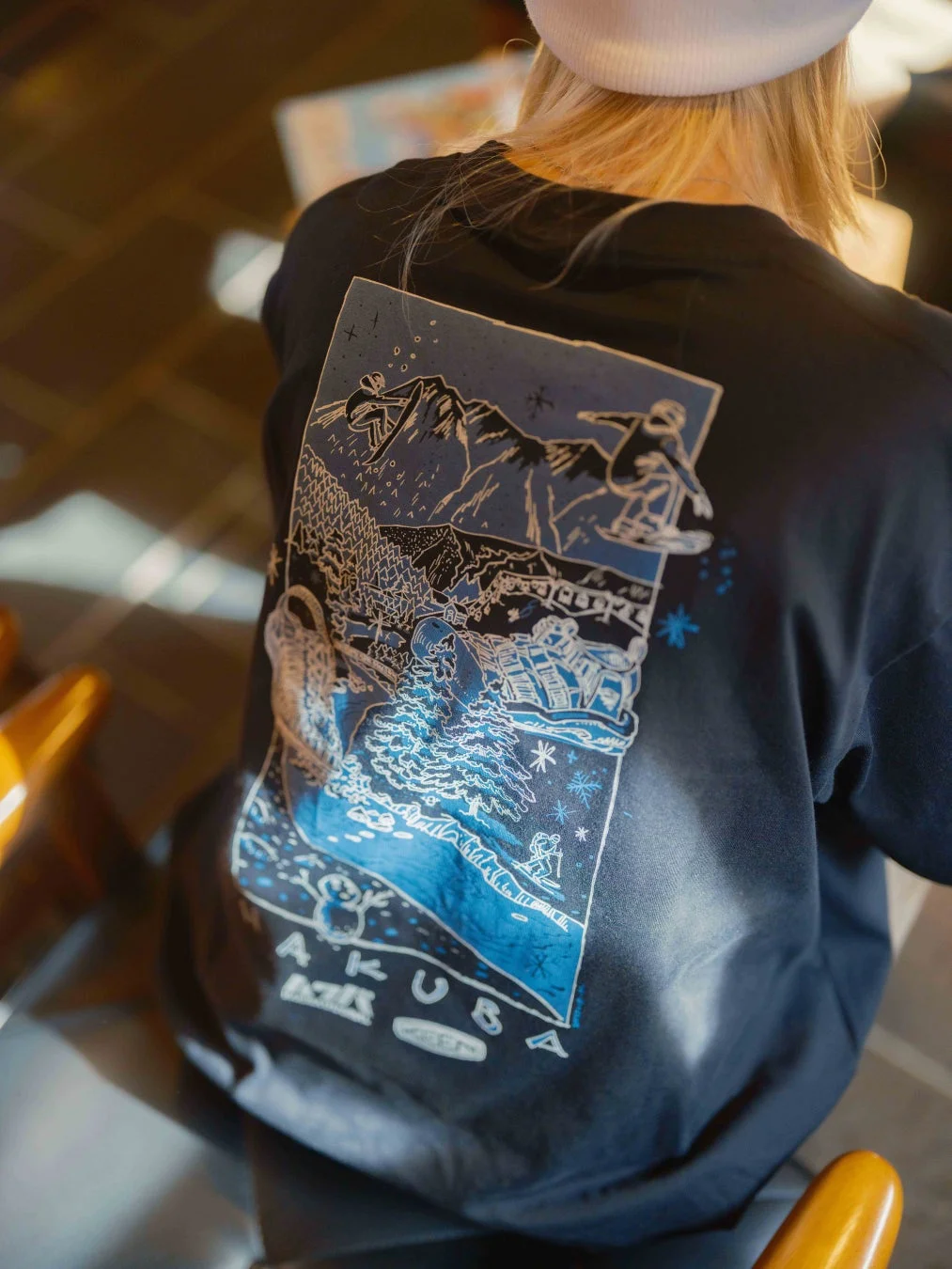 HAKUBAロゴ入りの黒いTシャツを着用した人物の後ろ姿