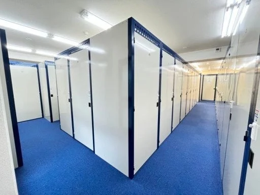 トランクルームの通路に白い収納ロッカーが並ぶ様子