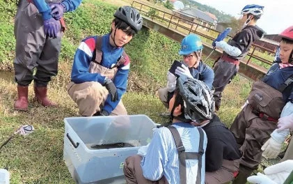 川辺で環境学習する人々