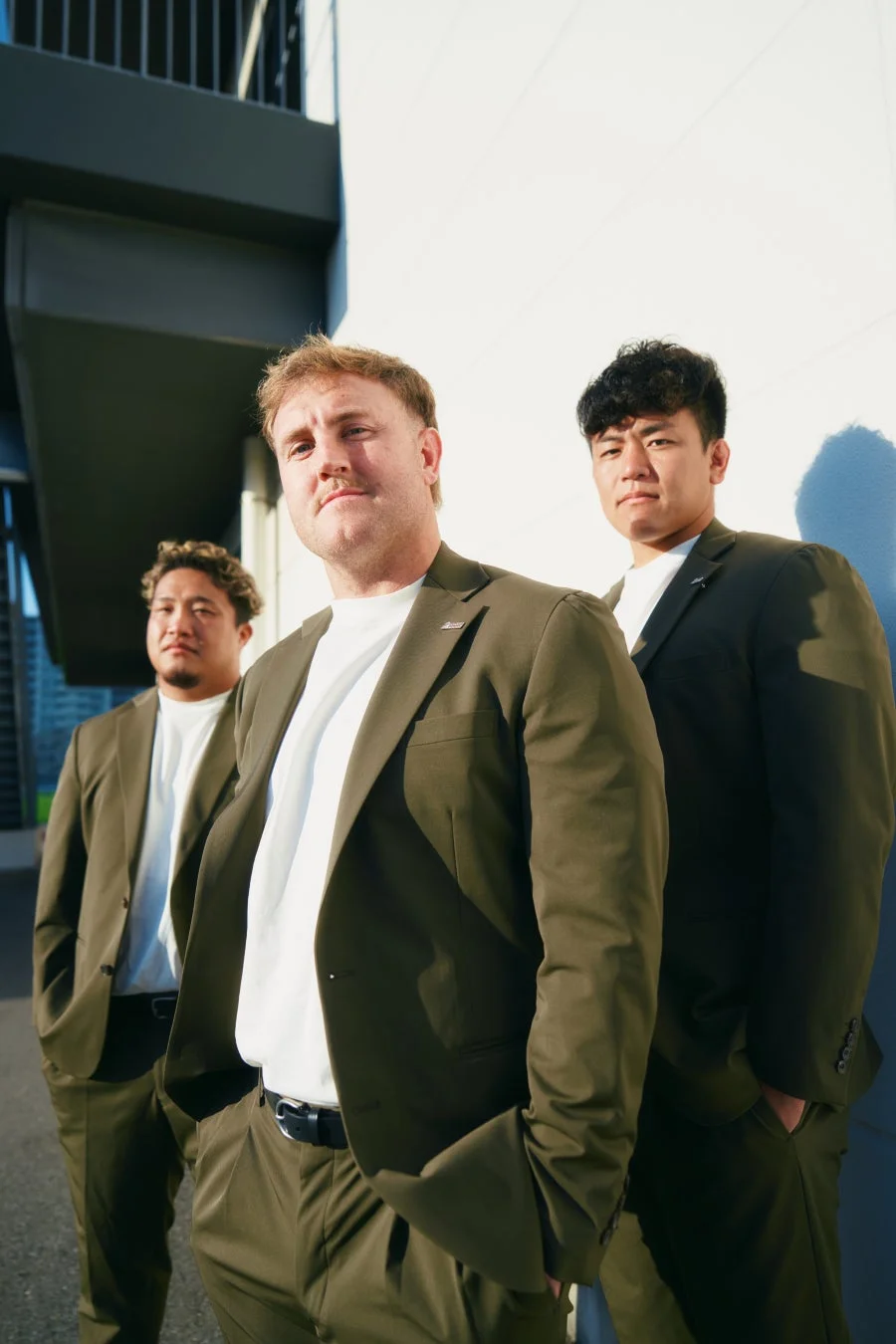 オリーブグリーンのスーツを着用した3人の男性