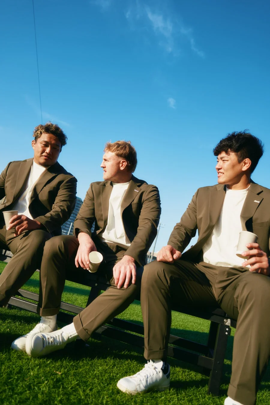 芝生の上でリラックスする3人の男性