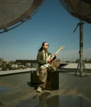 屋上でギターを弾く春野さんの様子