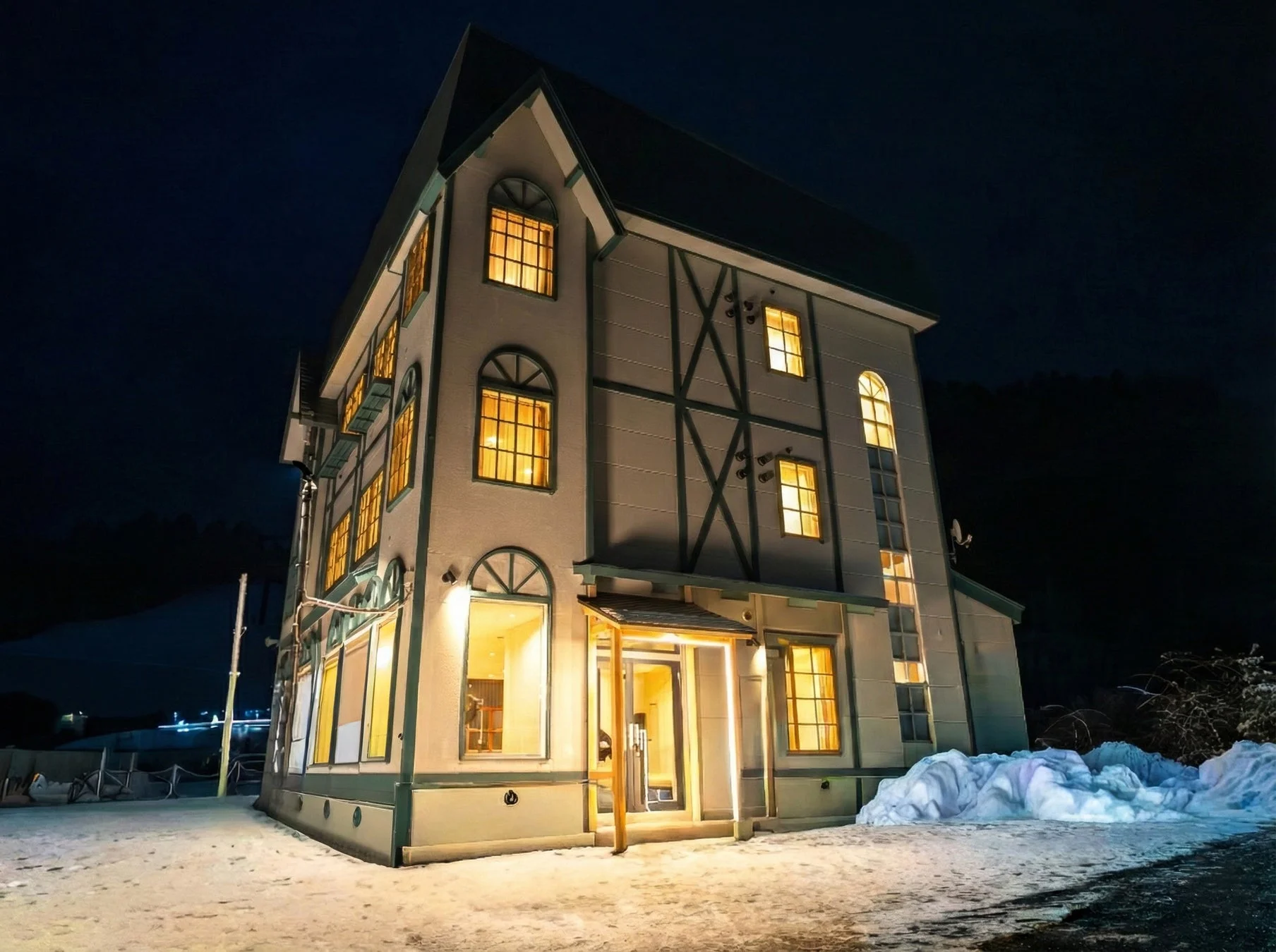 雪が積もる冬の夜にライトアップされた洋風の建物