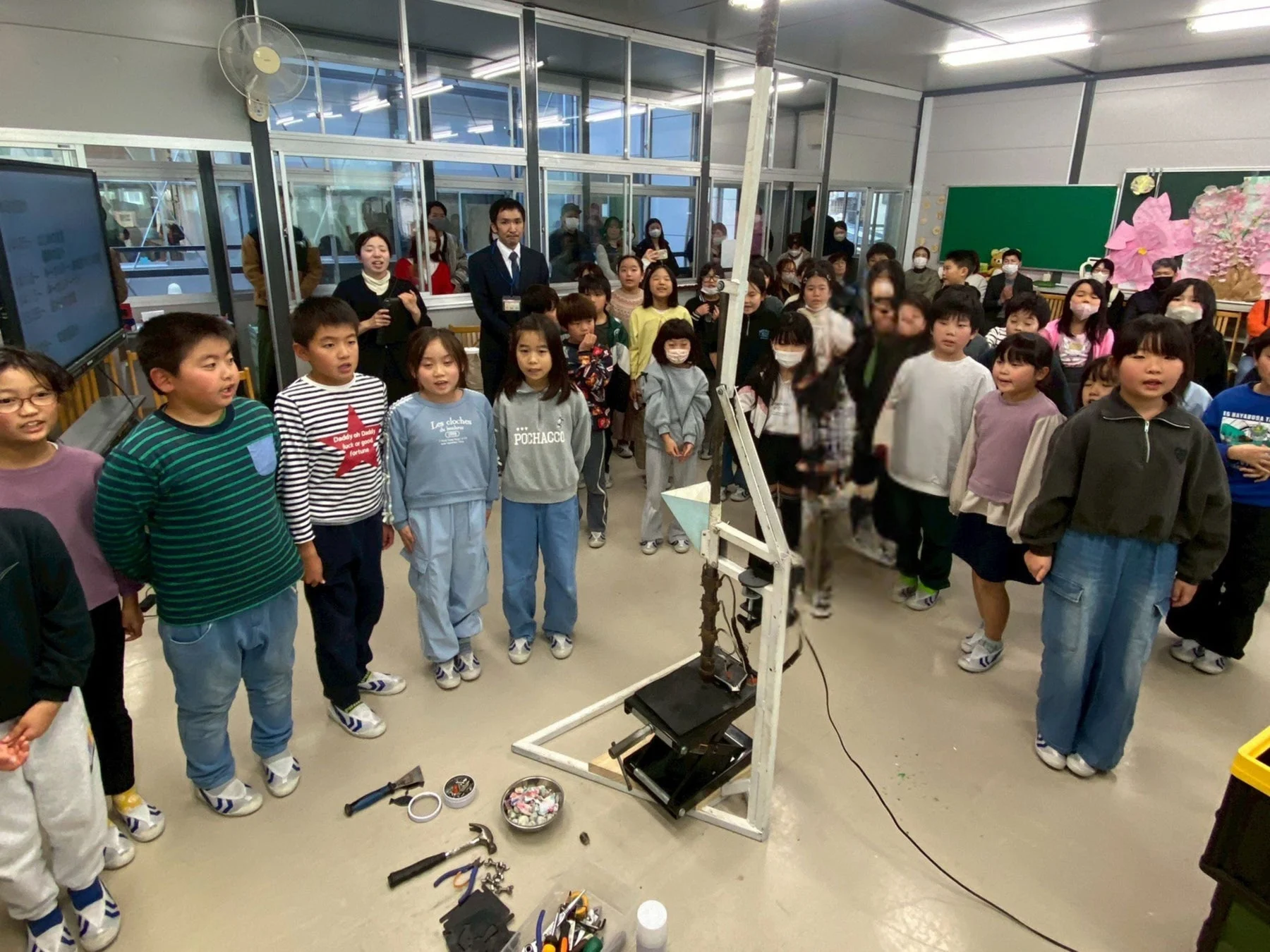 機材を使って制作する児童と大人