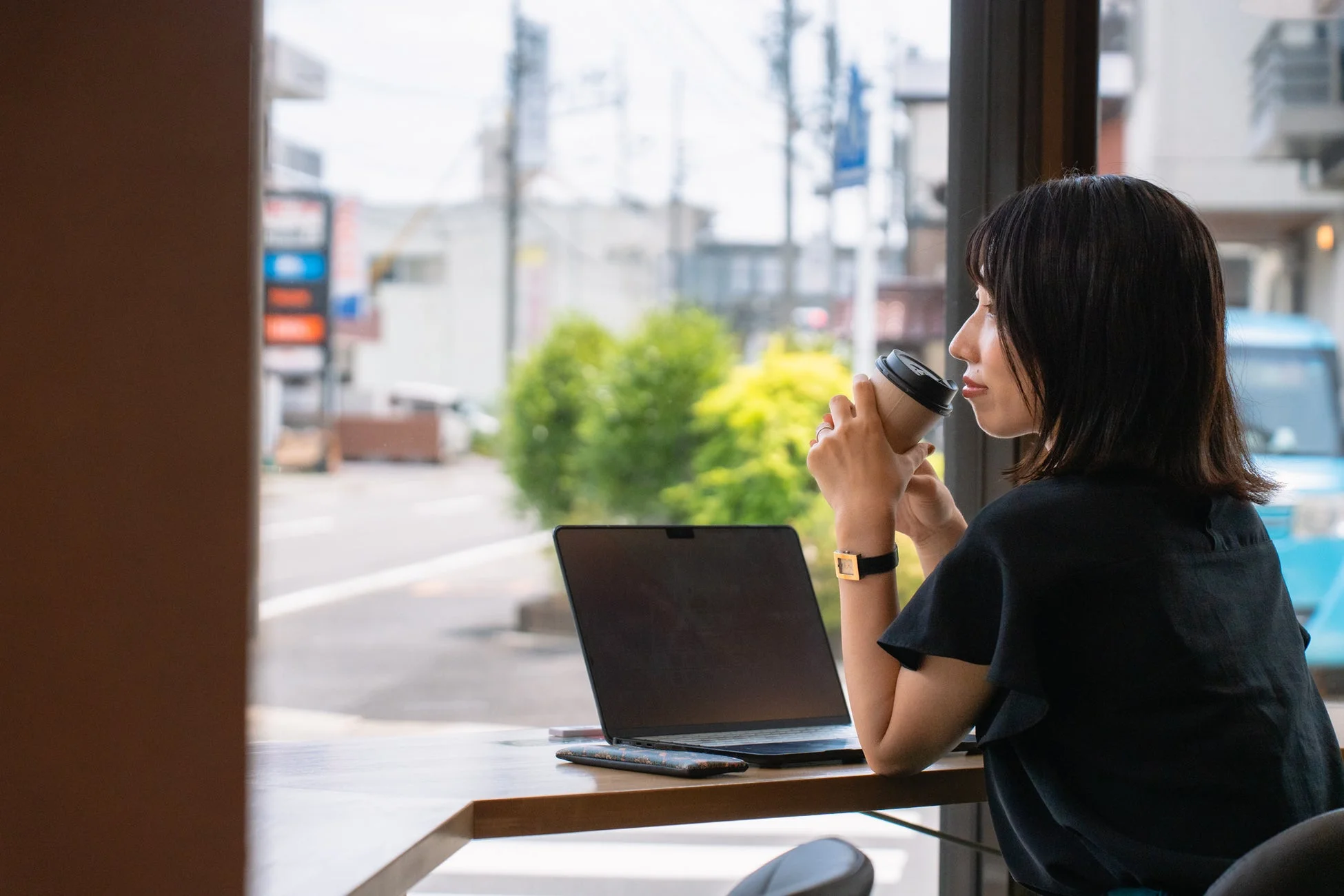 窓際でノートパソコンに向かう女性