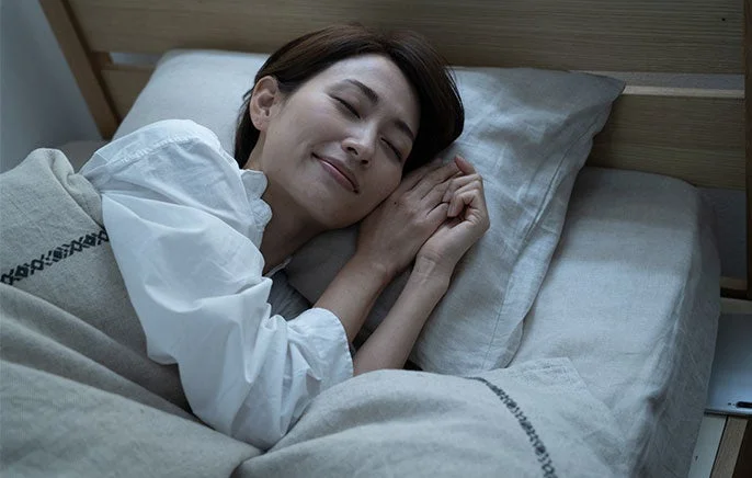 ベッドで安らかな寝顔を見せて眠る女性