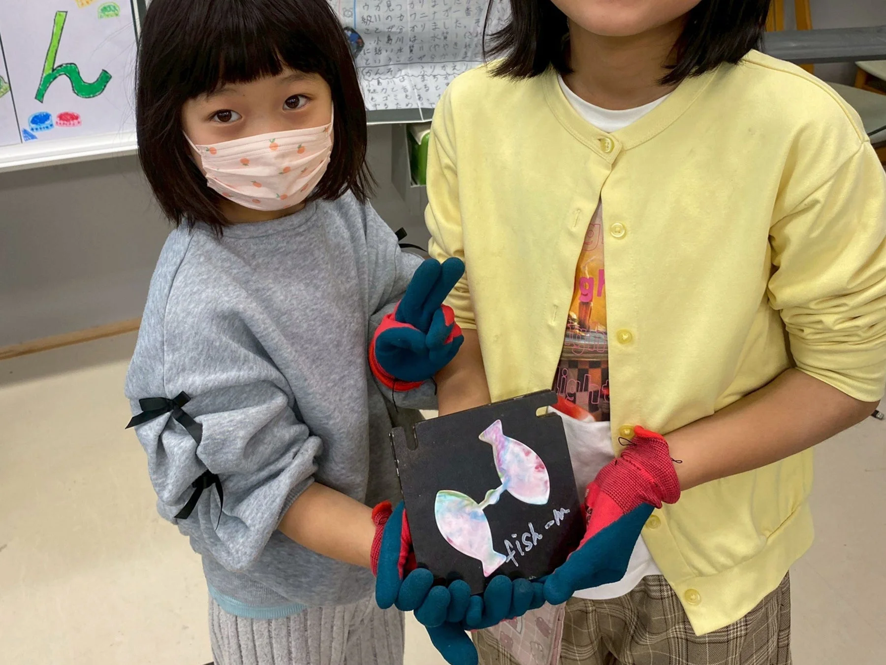 魚の工作品を持つ子供たち