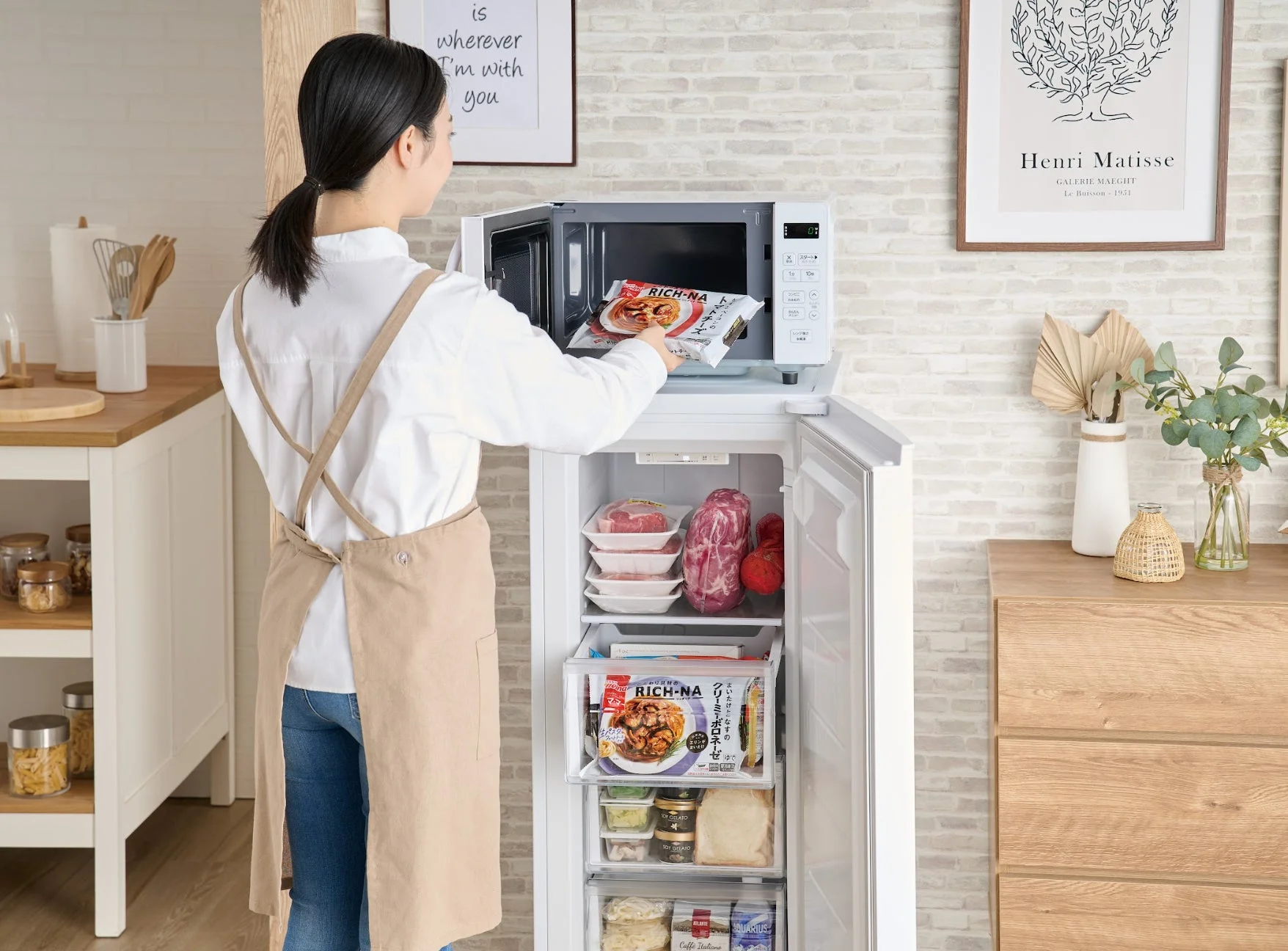 キッチンで電子レンジを使う女性