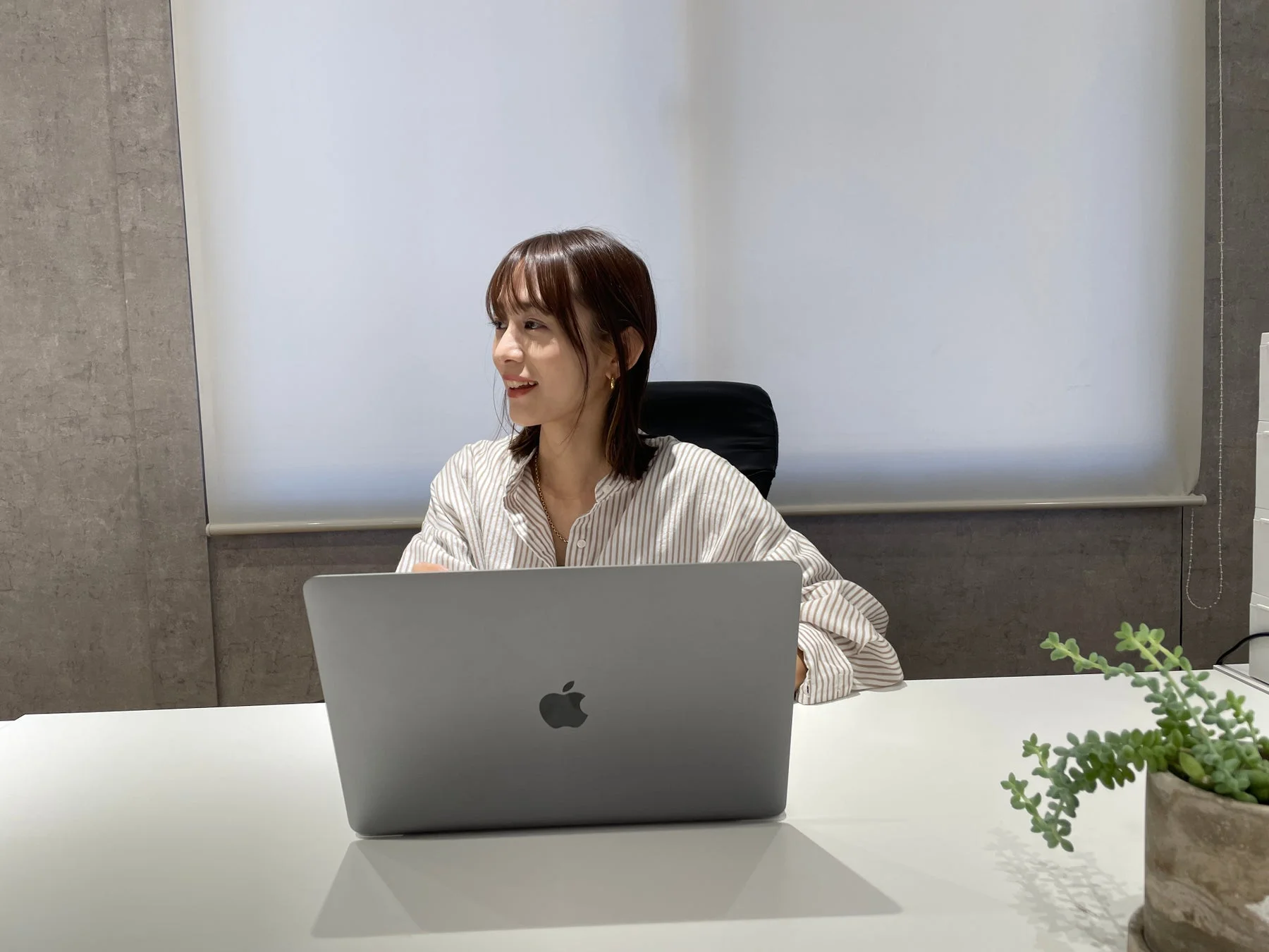 デスクでMacBookを使用中の女性