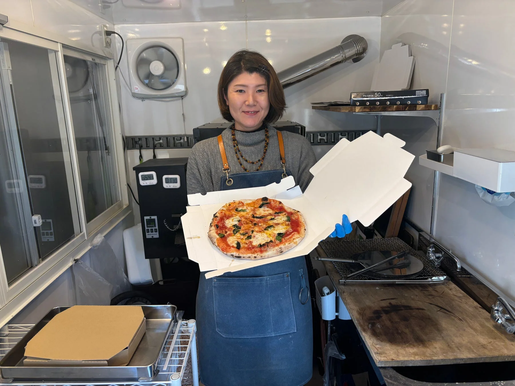 女性がピザを持つ