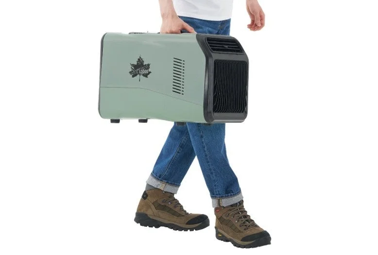 人物がロゴスのロゴが入った淡い緑色のポータブル冷暖房機を運んでいます。