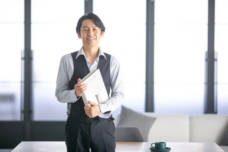 笑顔で本を抱える中島輝氏