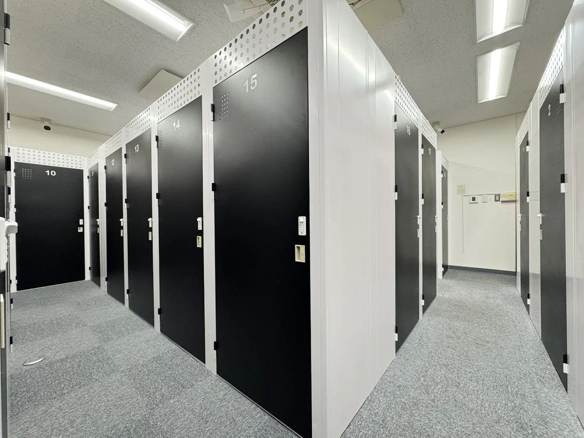 多数の黒い扉のロッカーが並ぶ屋内型のトランクルーム